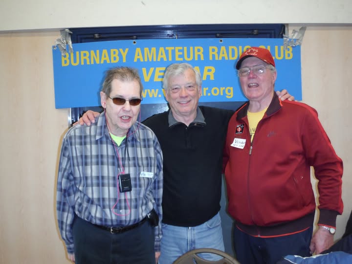 Walter Hendrickson, VE7BGJ, Graham, VE7ABC, and Lou Beaubien, VE7CGE, standing together at a Burnaby Amateur Radio Club gathering.